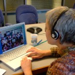 Photo of Lab of O Staff worker skyping witha group of students